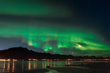 Aurora kumlu plaj haukland, Kvalvika ve Norveç, Lofoten Adaları içinde taş olan Skagsanden üzerinde. Kuzey ışıkları Lofoten Adaları, Norveç. Yıldızlı gökyüzü Kutup ışıkları. Yeşil gece manzarası