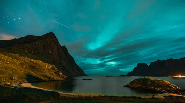 Aurora sobre haukland praia arenosa, Kvalvika e Skagsanden com pedras na Noruega, ilhas Lofoten. Luzes do norte nas ilhas Lofoten, Noruega. Céu estrelado com luzes polares. Paisagem noturna com verde — Fotografia de Stock