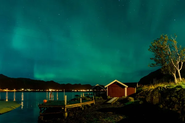 Aurora boreale aurora boreale sopra illuminato villaggio di pescatori di isole lofoten reine . — Foto Stock