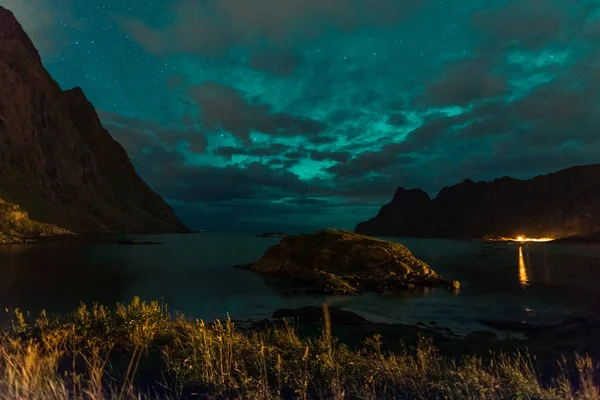 Aurora sobre haukland praia arenosa, Kvalvika e Skagsanden com pedras na Noruega, ilhas Lofoten. Luzes do norte nas ilhas Lofoten, Noruega. Céu estrelado com luzes polares. Paisagem noturna com verde — Fotografia de Stock