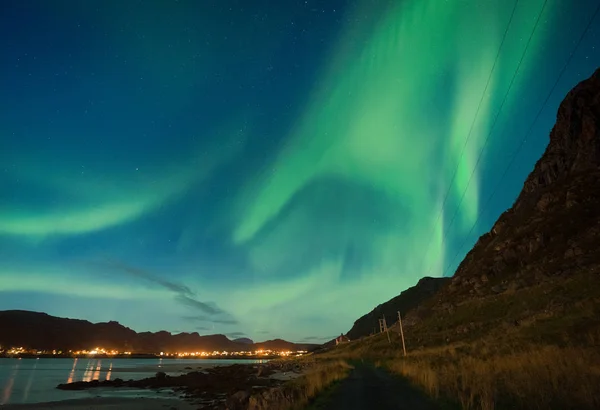 Aurora sobre haukland praia arenosa, Kvalvika e Skagsanden com pedras na Noruega, ilhas Lofoten. Luzes do norte nas ilhas Lofoten, Noruega. Céu estrelado com luzes polares. Paisagem noturna com verde — Fotografia de Stock