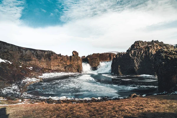 Διάσημοι Hjalparfoss διπλό καταρράκτη στη Νότια Ισλανδία με ουρανό και τα σύννεφα. ορεινή πεζοπορία στην Ισλανδία. Ταξίδια και τοπίο φωτογραφία έννοια — Φωτογραφία Αρχείου