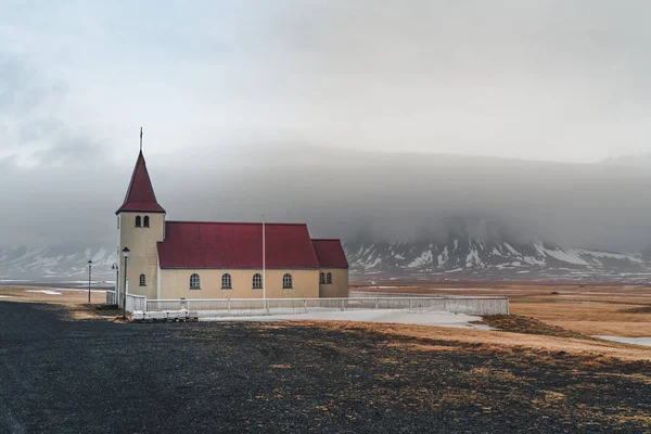 Colorida iglesia de madera roja y blanca en el paisaje con montaña glacial, Islandia rural — Foto de Stock