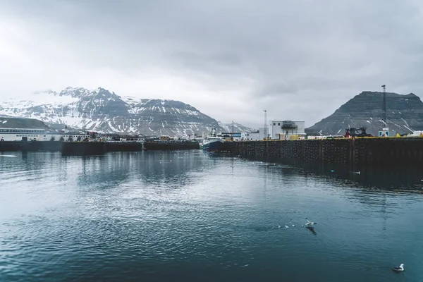 Grundarfjordur, IJsland - 03 januari 2019: Harbor met roerloos boten tijdens de schemering van de namiddag, Kirkjufell vulkanische berg op de achtergrond — Stockfoto