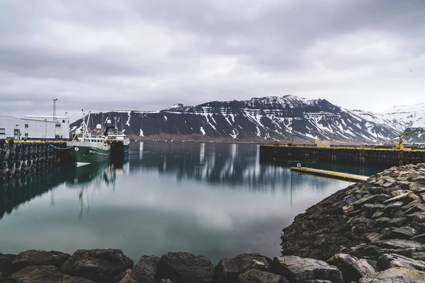 Grundarfjordur, Islandia - 03 de enero de 2019: Puerto con barcos inmóviles durante el crepúsculo de la tarde, Kirkjufell montaña volcánica en el fondo — Foto de Stock