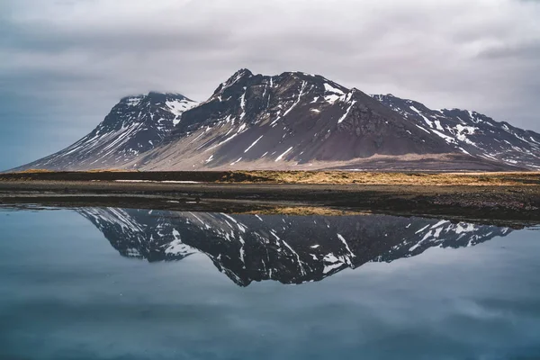 Reflejo de una montaña en Islandia en una bahía del océano Atlántico norte . — Foto de Stock