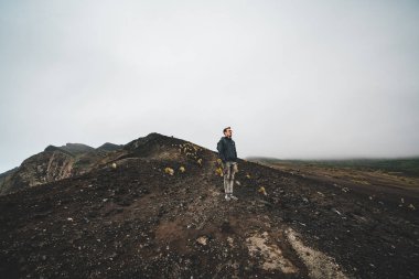Capelinhos yanardağı, Faial adasında batı kıyısında Ponta dos Capelinhos deniz feneri, Azores, Portekiz dramatik bir gün batımı ve güçlü dalgalar ve bulutlar ile görünümü. Son yanardağ patlaması oldu