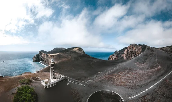 在阳光明媚的日子里,在葡萄牙亚速尔群岛的法亚尔岛(Faial Island)的蓬塔多斯卡佩利霍斯(Ponta dos Capelinhos)的灯塔上欣赏卡佩利霍斯火山,阳光明媚,天空和云彩波。上一次火山爆发是在1957年 — 图库照片