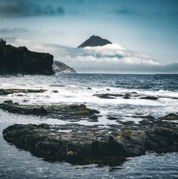 Monte Pico volcán pendiente occidental visto desde el océano con la cumbre en las nubes, visto desde la isla Faial en Azores, Portugal . — Foto de Stock