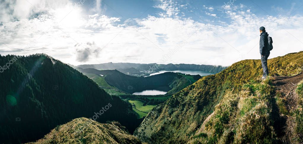 Young Man Tourist standing overlooking at Picturesque view of the Lake of Sete Cidades Seven Cities Lake , a volcanic crater lake on Sao Miguel island, Azores, Portugal. View from Vista do Rei