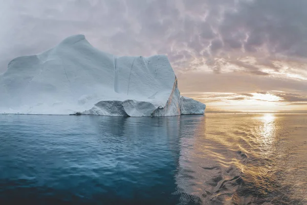 Arctisch natuurlandschap met ijsbergen in Groenlandse ijskerk met middernachtzon zonsondergang aan de horizon. Vroege ochtend zomer alpengloed tijdens middernacht seizoen. Ilulissat, West-Groenland. — Stockfoto