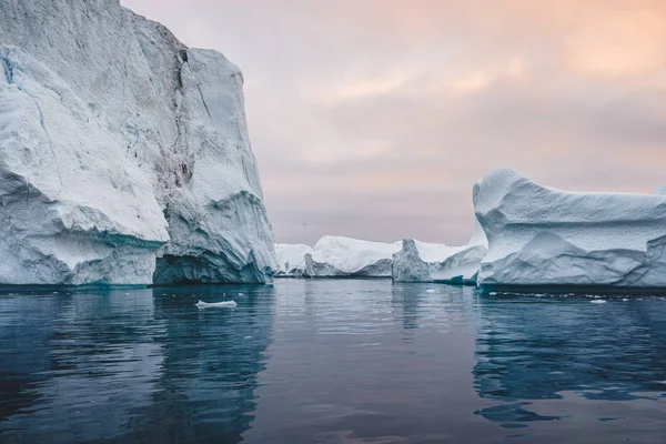 Arctisch natuurlandschap met ijsbergen in Groenlandse ijskerk met middernachtzon zonsondergang aan de horizon. Vroege ochtend zomer alpengloed tijdens middernacht seizoen. Ilulissat, West-Groenland. — Stockfoto