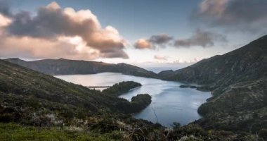 Timelapse Lagoa do Fogo Fire Lake 4k Sao Miguel Adası, Azores, Acores, Portekiz 'de günbatımından hızlandırılmış video klibi. Alacakaranlıkta pembe gökyüzü ve rüzgarlı koşullarda bulutlar..