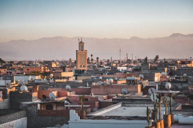 Günbatımında Marakeş 'i arka planda karla kaplı Atlas dağları ve ön planda Koutoubia camii ile izleyin. Fotoğraf müzesinin çatısından alındı..