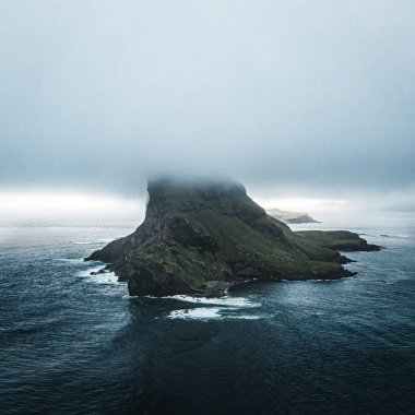 Faroe Adaları Tindholmur adalarının insansız hava aracı görüntüsü. Yazın yoğun bulutlar sırasında Atlantik Okyanusu 'nun koyu mavi suları ve yemyeşil sularıyla çekildi. Faroe Adaları, Danimarka, Avrupa
