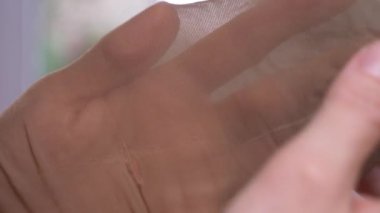 yakın çekim. Eller kapron çorap bütünlüğünü sınayın. bir yırtık külotlu çorap, 4k, ağır çekim