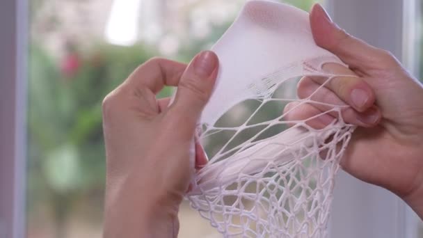 Närbild. Kvinnliga händer testa integriteten för Kapronlinor strumpor. en trasiga strumpbyxor, 4k, slow motion — Stockvideo