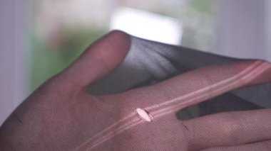 yakın çekim. Eller kapron çorap bütünlüğünü sınayın. bir yırtık külotlu çorap, 4k, ağır çekim