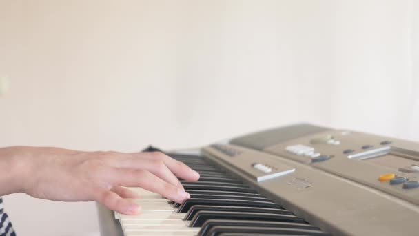 Detail. dětské ruce hrají syntezátor. na klavír. 4k, pomalý pohyb — Stock video