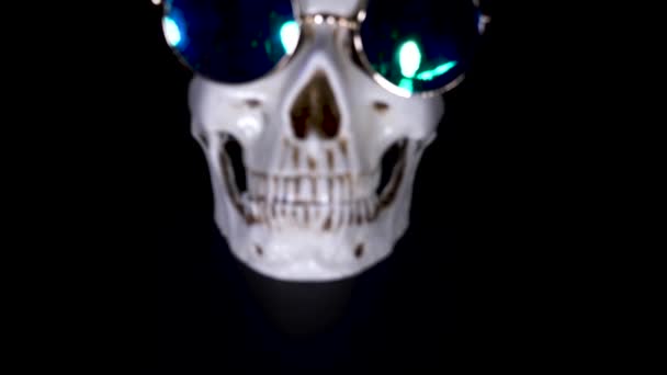 Halloween. el cráneo en una gorra festiva sobre un fondo negro. 4k, dolly shot . — Vídeos de Stock