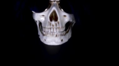 Kafatası siyah bir zemin üzerine yuvarlak güneş gözlüğü. yakın çekim. 4k, dolly shot, defocusing, bulanıklık.