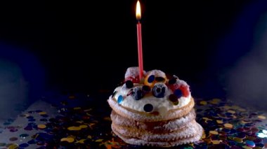 tatil, kutlama ve parti genel kavram - bir yanma ile Doğum günü kek siyah arka plan üzerinde konfeti mumlar. Konfeti bir parti için. 4k, ağır çekim