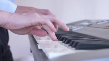 yakın çekim. dört el piyano. kadınsı ve erkeksi el birlikte bir synthesizer üzerinde oynayın. 4k, ağır çekim