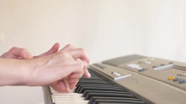 yakın çekim. bir piyano öğretmeni piyano çalmak için bir çocuk elleri ayarlama öğretir. 4k, ağır çekim