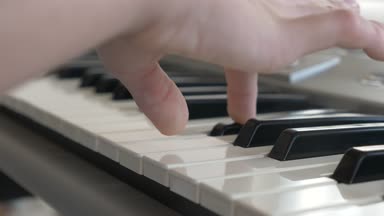 yakın çekim. Çocuk elinde bir synthesizer oynuyorlar. Piyano. 4k, ağır çekim