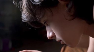 Sevimli genç çocuk odasına gece, bir smartphone kullanarak yatakta yatıyordu. telefonunu metni okur. 4 k kadar gözlerini kapat.