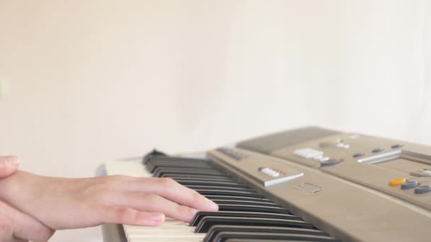 Primo piano. un insegnante di pianoforte insegna a un bambino a suonare il pianoforte, mettendo le mani. 4k, rallentatore — Video Stock