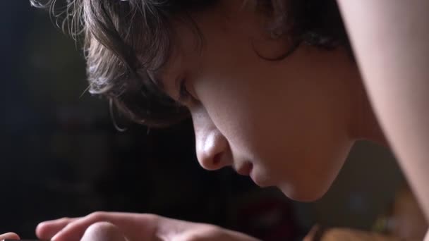 Schattige tiener jongen in zijn kamer 's nachts, liggend op het bed met behulp van een smartphone. Hij leest de tekst op zijn telefoon. ogen close-up van 4k. — Stockvideo