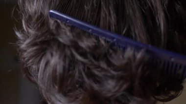 Saç doku arka plan, hiçbir kişi. Siyah parlak kıvırcık saçları tarak texturte. 4k, ağır çekim. yakın çekim