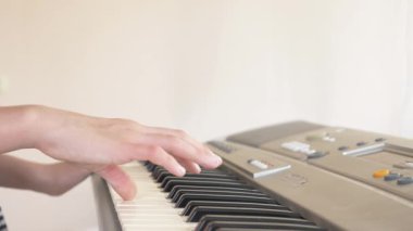 yakın çekim. bir piyano öğretmeni piyano çalmak için bir çocuk elleri ayarlama öğretir. 4k, ağır çekim