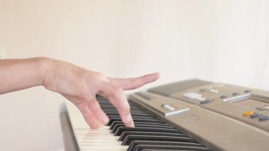 yakın çekim. Çocuk elinde bir synthesizer oynuyorlar. Piyano. 4k, ağır çekim