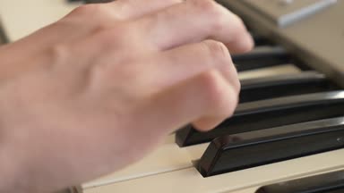 yakın çekim. Çocuk elinde bir synthesizer oynuyorlar. Piyano. 4k, ağır çekim