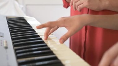 yakın çekim. dört el piyano. kadınsı ve çocuk ürünleri el birlikte bir synthesizer üzerinde oynayın. 4k, ağır çekim