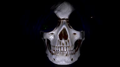 Kafatası siyah bir zemin üzerine yuvarlak güneş gözlüğü. yakın çekim. 4k, dolly shot, defocusing, bulanıklık.