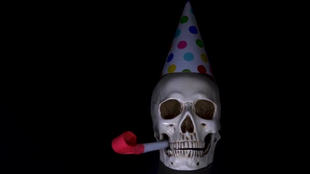 Halloween. el cráneo en una gorra festiva sobre un fondo negro. 4k, dolly shot . — Vídeo de stock