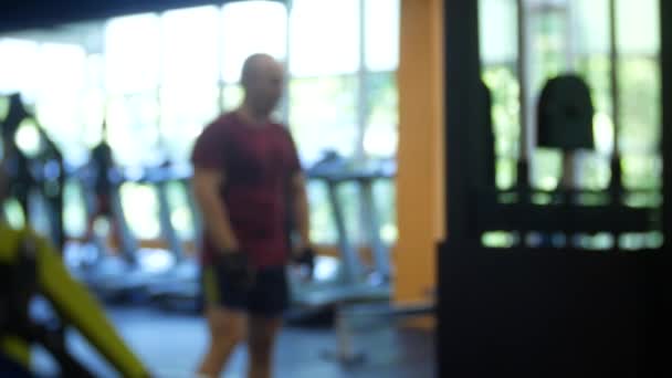 Verschwommen. Fitnessstudio-Leute trainieren im Sportzentrum. 4k — Stockvideo