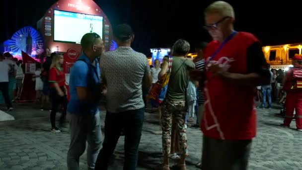 SOCHI, RUSIA - 15 de junio de 2018: FIFA 2018. transmitió el juego en la pantalla en el puerto. empleados de asistencia médica y patrulla policial fiestas populares . — Vídeos de Stock