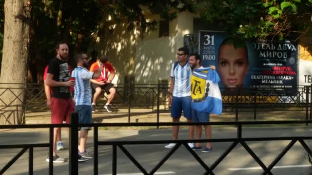 SOCHI, RÚSSIA - 16 de junho de 2018: FIFA 2018. Os fãs de futebol caminham no parque ao lado do porto. 4k . — Vídeo de Stock