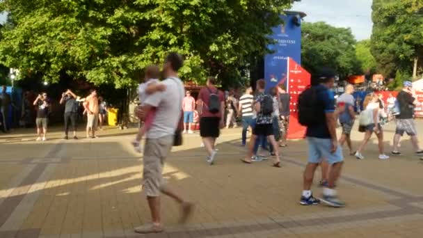 SOCHI, RÚSSIA - 16 de junho de 2018: FIFA 2018. Os fãs de futebol caminham no parque ao lado do porto. 4k . — Vídeo de Stock