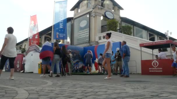 SOCHI, RÚSSIA - 16 de junho de 2018: FIFA 2018. Os fãs de futebol caminham no parque ao lado do porto. 4k . — Vídeo de Stock