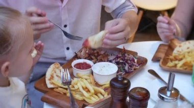 4k, yakın çekim. Baba ve küçük kızı lokanta fast food restoran terasında yemek.