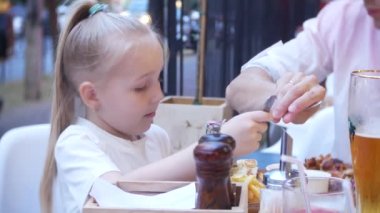 4k, yakın çekim. Baba ve küçük kızı lokanta fast food restoran terasında yemek.