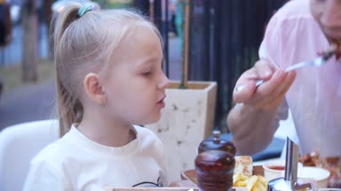 4k, yakın çekim. Baba ve küçük kızı lokanta fast food restoran terasında yemek.