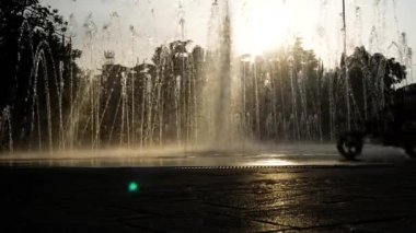 Çocuk siluetleri bir yaz günü kentin fıskiyede oynamak. 4k.