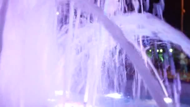 Ein Brunnen mit farbigem Wasserlicht, abends. Nahaufnahme, Unschärfe, 4k — Stockvideo