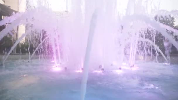 Una fuente con iluminación de agua de colores, por la noche. primer plano, desenfoque, 4k — Vídeos de Stock